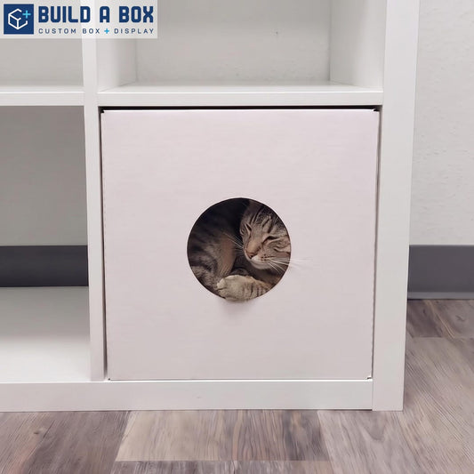 White cardboard cat house in cube shelf